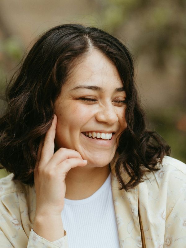 Woman smiling outdoors after same day dental crown treatment in Denver