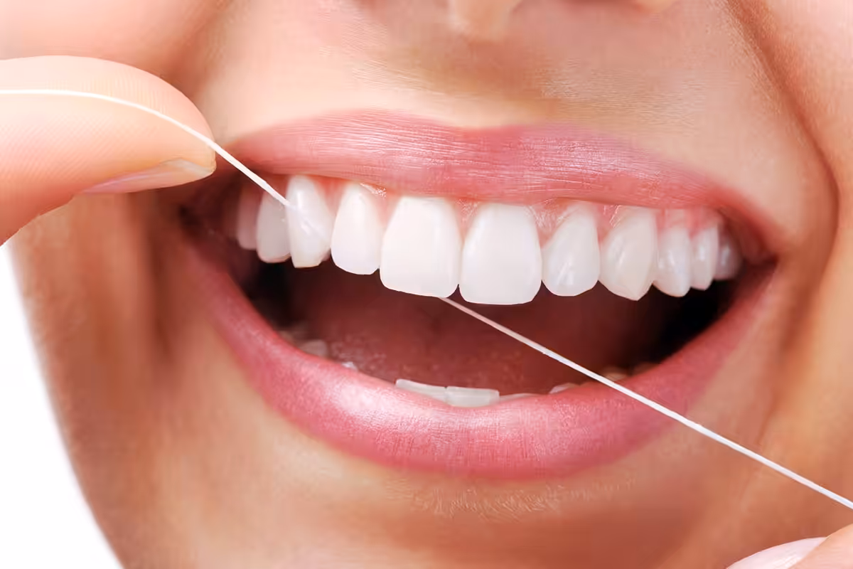 Patient flossing between professional dental cleanings at a Denver dental office